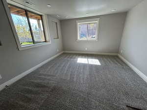 Unfurnished room featuring baseboards, visible vents, a healthy amount of sunlight, and carpet