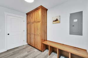 Mudroom featuring electric panel and light wood-type flooring