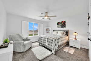Carpeted bedroom featuring baseboards, a ceiling fan, and visible vents
