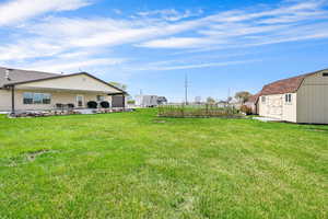 View of yard with an outbuilding, a shed, and a patio
