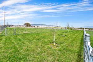 View of yard featuring a gate, fence, a rural view, and a mountain view