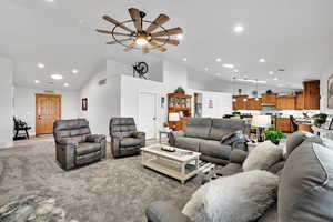 Living room featuring visible vents, recessed lighting, light colored carpet, ceiling fan, and high vaulted ceiling
