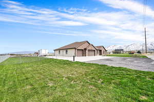 Exterior space featuring an attached garage, driveway, fence, and a mountain view