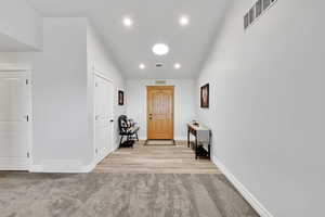 Corridor with baseboards, carpet floors, visible vents, and recessed lighting
