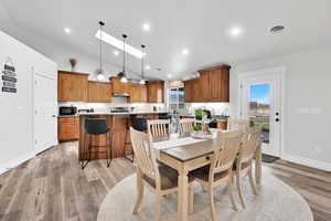 Dining space with recessed lighting, lofted ceiling, visible vents, light wood-style floors, and baseboards