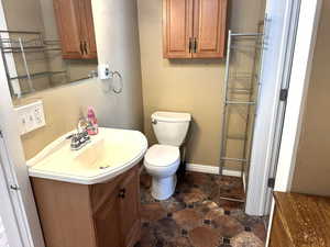 Bathroom with baseboards, toilet, and vanity