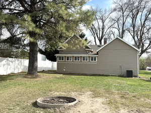 Back of property with large pine tree and fire pit