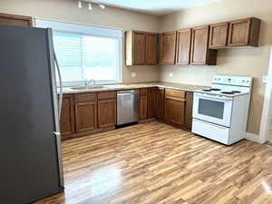 Kitchen featuring stainless steel appliances, concrete countertops and laminate floor