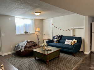 Living area with baseboards and a textured ceiling