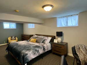 Carpeted bedroom featuring baseboards and a textured ceiling