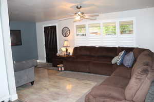 Living area with a ceiling fan, wood finished floors, and a wealth of natural light