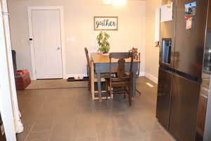 Tiled dining space featuring baseboards
