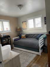 Bedroom featuring wood finished floors and multiple windows