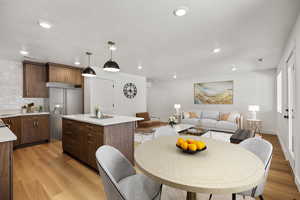 Dining area with light wood-type flooring, recessed lighting, and a textured ceiling