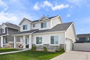 Craftsman house featuring a porch, stone siding, concrete driveway, a garage, and a front yard