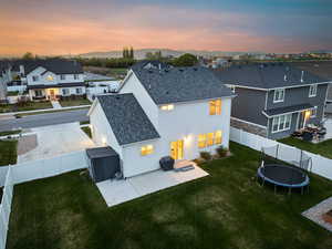 Back of property with a fenced backyard, a residential view, a trampoline, and stucco siding