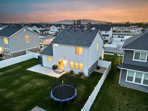 Back of property with a yard, a residential view, a trampoline, and a fenced backyard