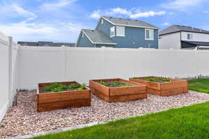 View of yard with a fenced backyard and a garden