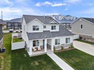Modern inspired farmhouse featuring an outdoor hangout area, a front lawn, cooling unit, stone siding, and a mountain view