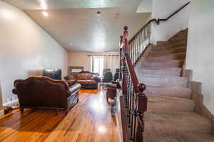 Living room with wood finished floors and stairway