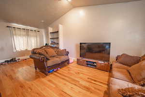 Living area featuring lofted ceiling and wood finished floors