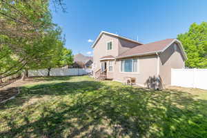Rear view of house with entry steps and stucco siding