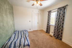 Unfurnished bedroom featuring carpet floors, a ceiling fan, visible vents, and baseboards