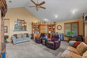 Carpeted living area with a ceiling fan, baseboards, recessed lighting, and vaulted ceiling