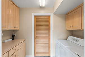 Laundry room featuring cabinet space and washer and clothes dryer