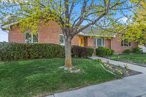 View of front of property with brick siding and a front yard