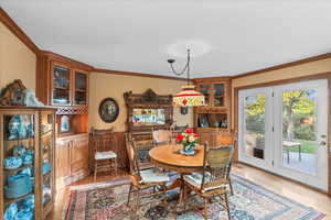 Dining space featuring light wood-style floors, visible vents, and ornamental molding