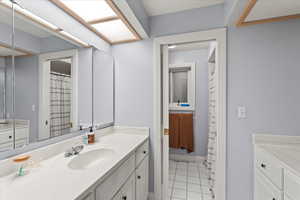 Bathroom featuring baseboards, vanity, and tile patterned flooring