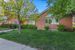 Ranch-style house featuring brick siding and a front lawn