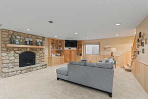 Living area with stairs, wainscoting, carpet floors, a fireplace, and recessed lighting