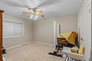 Carpeted home office featuring baseboards and ceiling fan