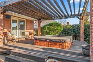 Wooden deck featuring a covered hot tub