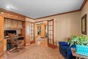Office with built in study area, baseboards, ornamental molding, and french doors