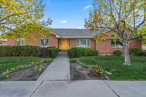 Single story home featuring a front lawn and brick siding