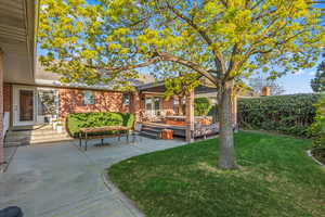 View of yard with a wooden deck, a patio, and fence
