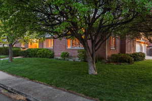 View of property exterior featuring a lawn, brick siding, and a garage