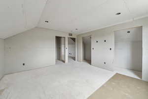Unfurnished bedroom featuring two closets, lofted ceiling, and visible vents