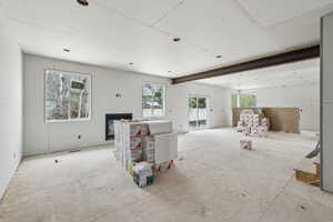 Unfurnished living room featuring a glass covered fireplace