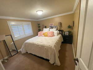 Bedroom featuring baseboards, crown molding, and carpet floors