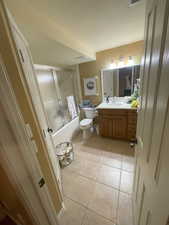 Bathroom with tile patterned flooring, enclosed tub / shower combo, visible vents, toilet, and vanity