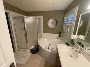 Bathroom featuring a bath, a shower stall, vanity, and tile patterned floors