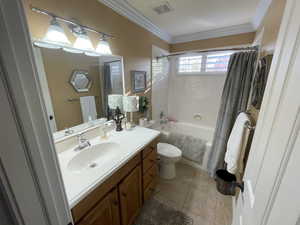 Bathroom with visible vents, toilet, vanity, shower / tub combo with curtain, and crown molding