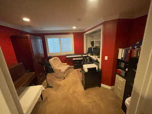 Sitting room with carpet floors, crown molding, and recessed lighting