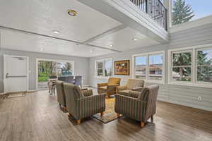 Living area with baseboards, wood finished floors, recessed lighting, and a textured ceiling