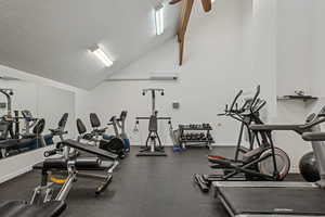 Gym featuring baseboards, vaulted ceiling, ceiling fan, and a wall mounted air conditioner