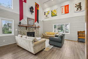 Living area featuring a fireplace, wood finished floors, high vaulted ceiling, and rail lighting